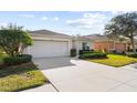 Exterior view of a house with a two-car garage and lush landscaping at 5198 Layton Dr, Venice, FL 34293