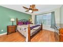 Inviting bedroom with wood floors, ceiling fan, and large window with shutters at 5856 Helicon Pl, Sarasota, FL 34238