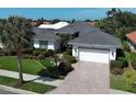 Attractive home featuring a tile roof, well-kept lawn, and a paver driveway leading to a two-car garage at 589 Pond Willow Ln, Venice, FL 34292