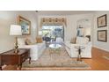 Formal living room with white sofas, a glass coffee table, and views of the backyard at 709 Petrel Way, Venice, FL 34285