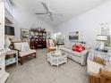 Coastal-themed living room with white sofa, wicker chairs, and decorative accents at 751 Capri Isles Blvd # 108, Venice, FL 34292