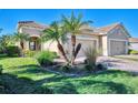 Two-story house with palm trees, lush landscaping, and a paved driveway at 11539 Okaloosa Dr, Venice, FL 34293