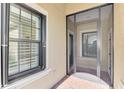 Covered entryway with a screened door and window with white plantation shutters at 11539 Okaloosa Dr, Venice, FL 34293