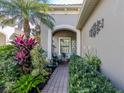 Charming entryway with a relaxing seating area and lush landscaping at 1195 Collier Pl, Venice, FL 34293