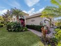 Attractive curb appeal with lush landscaping and a brick walkway at 1195 Collier Pl, Venice, FL 34293