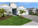 Two-story house with light blue exterior, three car garage, and palm trees at 12472 Meribel St, Venice, FL 34293