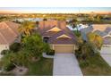 Beautiful aerial view of a home showcasing a tile roof and a scenic lake in a vibrant community at 1307 Highland Greens Dr, Venice, FL 34285