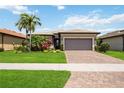 Beautiful one-story home with a lush landscaped yard and a two-car garage, set under a bright blue sky at 13510 Esposito St, Venice, FL 34293