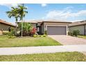 Beautiful one-story home with a lush landscaped yard and a two-car garage, set under a bright blue sky at 13510 Esposito St, Venice, FL 34293