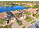 Several homes in a community with a lake, showcasing similar design and lush landscaping at 20336 Pezzana Dr, Venice, FL 34292