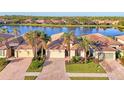 Community of homes near a lake, showcasing similar architecture and landscaping at 20336 Pezzana Dr, Venice, FL 34292