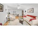 Living room with hardwood floors, white couch, and a ceiling fan at 4160 Fruitville Rd # 14, Sarasota, FL 34232