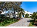 Single-story home with a light-colored exterior, lush landscaping, and a paved driveway at 515 Governors Green Dr, Venice, FL 34293