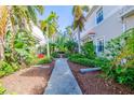 Landscaped walkway leading to residential buildings with lush tropical foliage at 7000 Ibis Way # 101, Venice, FL 34292