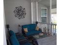 Relaxing covered porch with teal seating and sunburst wall art at 813 Stymie Pl # 426, Venice, FL 34285