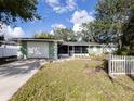 House exterior featuring green paint, white picket fence, and landscaping at 907 Shasta Rd, Venice, FL 34293