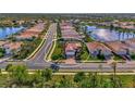 Stunning aerial view of a single-Gathering home with lush landscaping and a lake view in a desirable community at 11679 Anhinga Ave, Venice, FL 34292