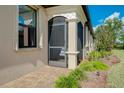 Home exterior featuring a screened patio and landscaping at 12313 Amica Loop, Venice, FL 34293