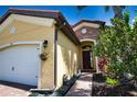 House entrance with a walkway, landscaping, and a two-car garage at 140 Maraviya Blvd, Nokomis, FL 34275