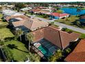 Aerial view showcasing the property's landscaping, screened-in pool, and tile roof at 1678 Quail Lake Dr, Venice, FL 34293