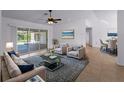 Open-concept living room features a sliding glass door that provides access to the private pool area at 1678 Quail Lake Dr, Venice, FL 34293
