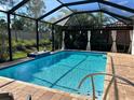 Inviting screened-in pool area with brick paving, serene landscaping, and relaxing ambiance at 232 Benedetto Ct, Nokomis, FL 34275