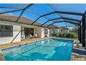 Beautiful screened-in pool with brick patio and views of well-maintained landscaping at 232 Benedetto Ct, Nokomis, FL 34275