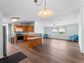 Open kitchen with wood cabinets, stainless steel appliances, and vinyl flooring at 512 Ashwood Dr, Venice, FL 34285
