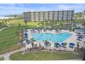 Stunning pool area with lounge chairs and umbrellas, surrounded by lush landscaping at 5790 Midnight Pass Rd # 602, Sarasota, FL 34242