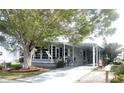 Gray mobile home with covered porch and landscaped yard at 727 Blackburn Blvd, North Port, FL 34287
