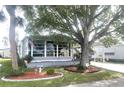 Gray mobile home with large tree and American flag at 727 Blackburn Blvd, North Port, FL 34287