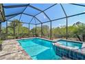 Beautiful screened-in pool and jacuzzi with brick paver patio and backyard view at 125 Soliera St, Nokomis, FL 34275