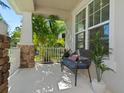 Relaxing covered porch with seating, stone accents, and view of tropical foliage at 5930 Anise Dr, Sarasota, FL 34238