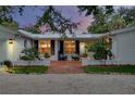 Inviting red brick front porch with seating and beautiful landscaping creates a welcoming entrance at 705 Armada N Rd, Venice, FL 34285