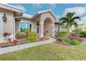 Close-up of the home's entrance with manicured landscaping and a paved walkway at 1558 Belfry Dr, Venice, FL 34292