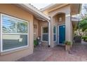 Charming front entrance with brick pavers, a teal door, and tasteful landscaping elements at 201 Auburn Woods Cir, Venice, FL 34292