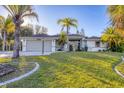 Charming single-story home featuring a two-car garage, well-maintained lawn, and tropical landscaping at 2899 Ensenada Ln, North Port, FL 34286
