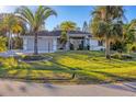 Charming single-story home featuring a two-car garage, well-maintained lawn, and tropical landscaping at 2899 Ensenada Ln, North Port, FL 34286