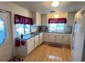 Bright kitchen featuring white cabinetry, modern appliances, and wood laminate flooring at 356 Longwood Dr, Venice, FL 34285