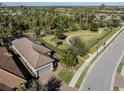 Aerial view showcasing a well-landscaped property with a manicured lawn, and walking path at 5733 Semolino St, Nokomis, FL 34275