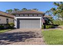 Attached two-car garage with paver driveway and neatly landscaped yard at 5733 Semolino St, Nokomis, FL 34275