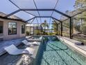 Relaxing screened-in pool area featuring in-pool loungers and scenic water views at 5733 Semolino St, Nokomis, FL 34275
