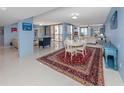 Bright living area with tile floors, blue accent wall and open layout to dining and balcony at 2020 Harbourside Dr # 424, Longboat Key, FL 34228