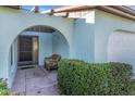 Inviting front entrance featuring an arched entryway, decorative shrubbery, and a cozy wicker chair at 507 Foxwood Blvd # 4, Englewood, FL 34223