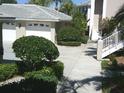 Townhome with white garage door and well maintained, manicured landscaping at 111 Woodbridge Dr # 204, Venice, FL 34293