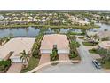 Aerial view of neighborhood homes showcasing tile roofs, private pools, and serene lake views at 13364 Dimarco St, Venice, FL 34293