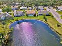 Aerial view of home on the water showing pool, screened patio, and lush backyard at 1815 Killdeer Ct, Venice, FL 34293