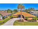 Beautiful single-story home featuring a well-manicured lawn, circular driveway, and mature palm tree at 1815 Killdeer Ct, Venice, FL 34293