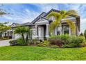 Charming single-story home featuring a well-manicured lawn and lush tropical landscaping at 19807 Bridgetown Loop, Venice, FL 34293