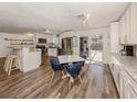 Open kitchen and dining area with white cabinets, stainless appliances, and a sliding glass door to the patio at 4911 Pompano Rd, Venice, FL 34293